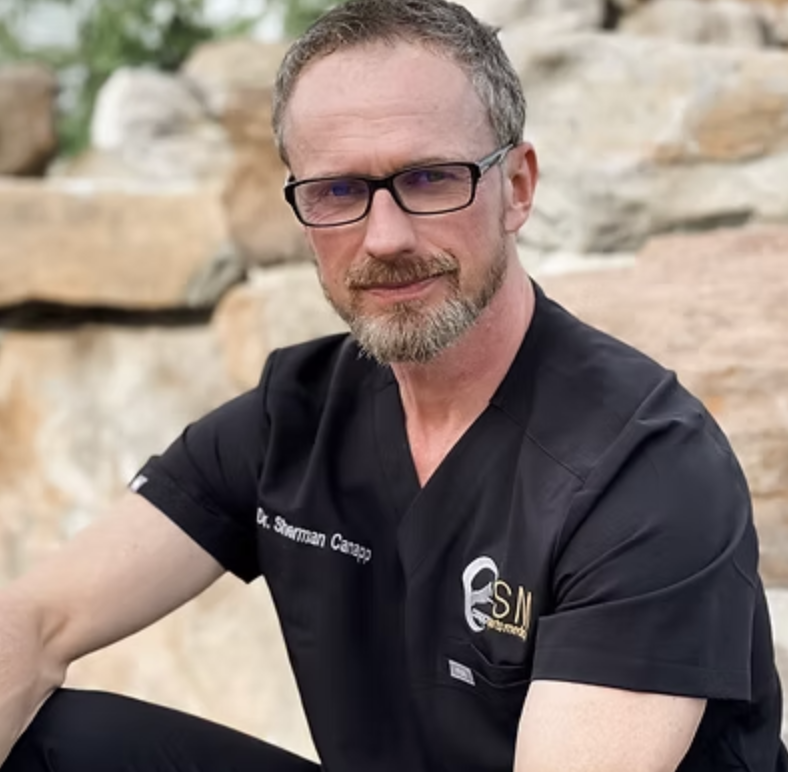 Dr.Sherman Canapp facing camera wearing veterinary scrubs